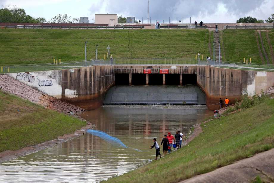 A man throws a cast net into the Buffalo Bayou with the Barker Dam and Barker Reservoir in the background in Houston, Texas. The Barker Reservoir and Barker Dam in conjunction with the Addicks Reservoir prevent downstream flooding of Buffalo Bayou in the City of Houston. ( Gary Coronado / Houston Chronicle ) Photo: Gary Coronado, Staff / © 2015 Houston Chronicle